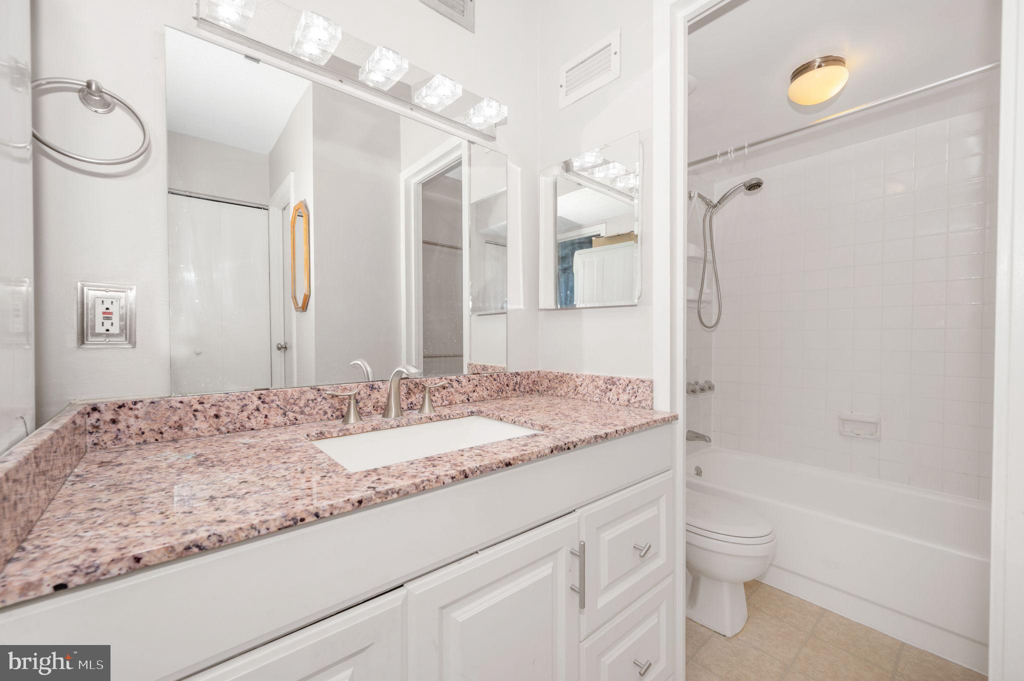 6800 Fleetwood Road, Unit 509 McLean, VA 22101 - Photo 20 of 48 a bathroom with a granite countertop sink a toilet and a bathtub