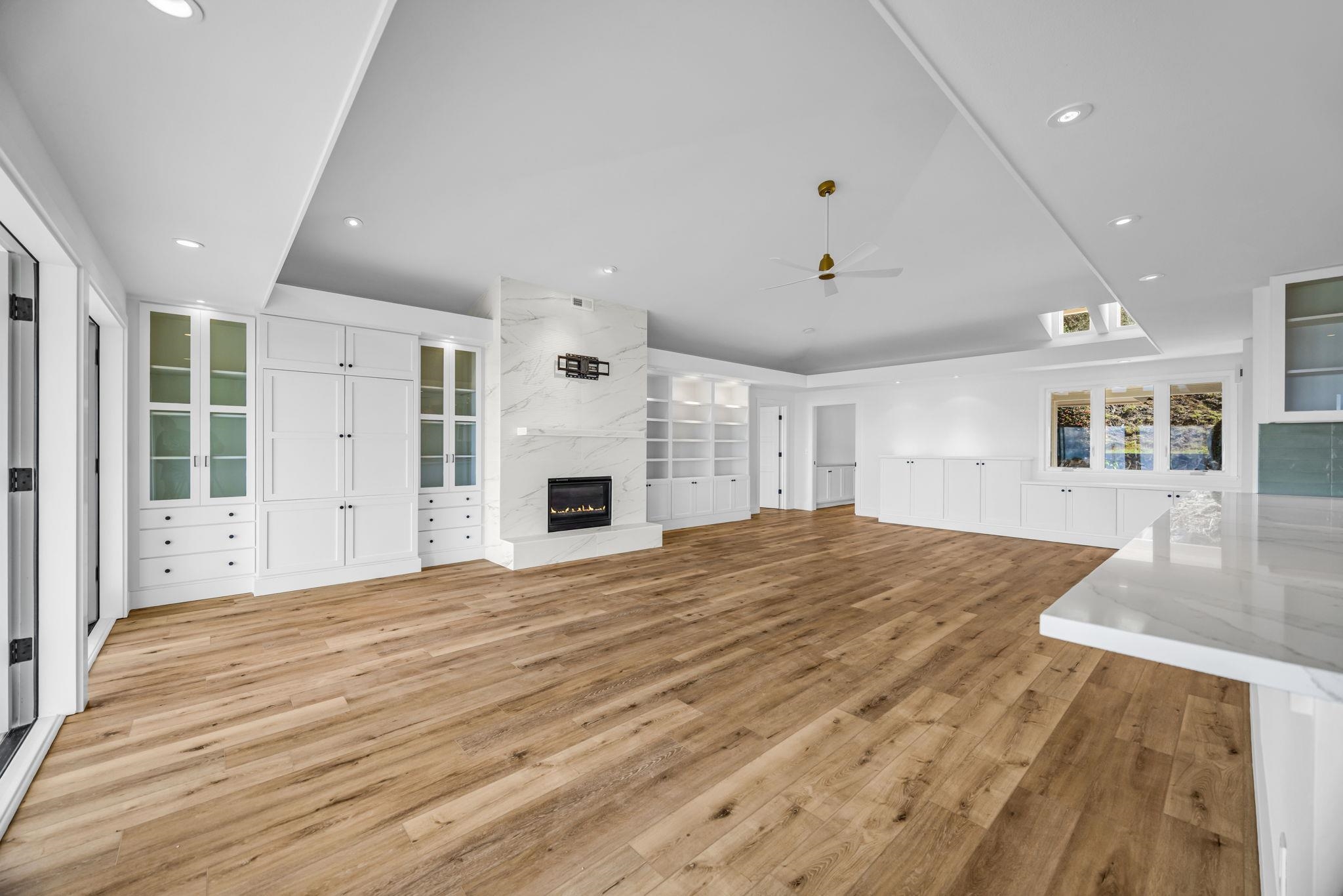 7733 Kula Highway Kula, HI 96790 - Photo 14 of 43 a view of an empty room with wooden floor and a kitchen