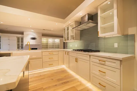 a large kitchen with cabinets and wooden floor