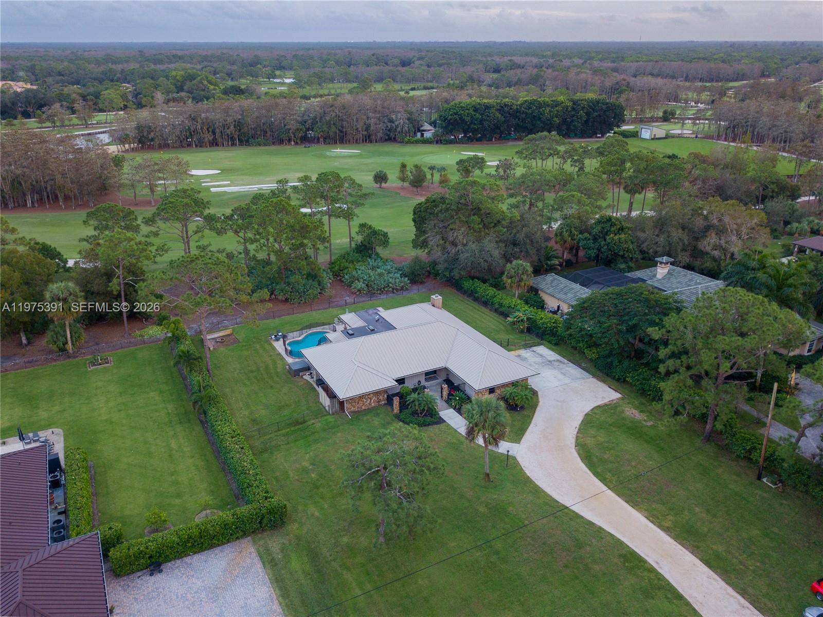 1872 Southeast Colony Way Jupiter, FL 33478 - Photo 12 of 26 an aerial view of green landscape with trees houses and mountain view