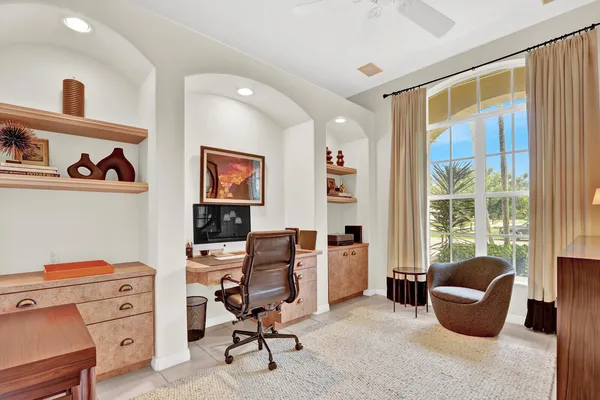 a view of a workspace with furniture and a window