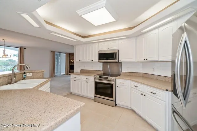 a kitchen with white cabinets stainless steel appliances and sink