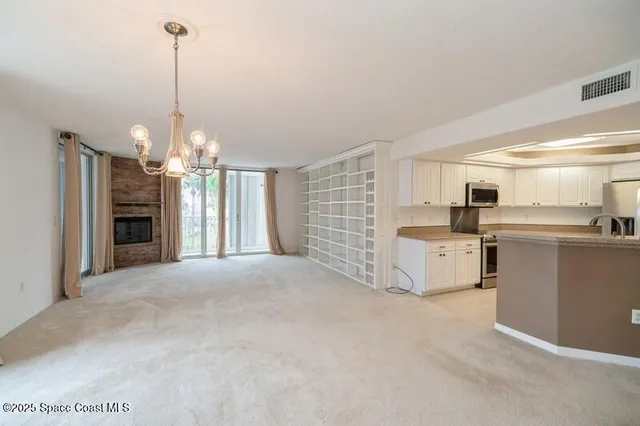 a view of a kitchen with refrigerator and window
