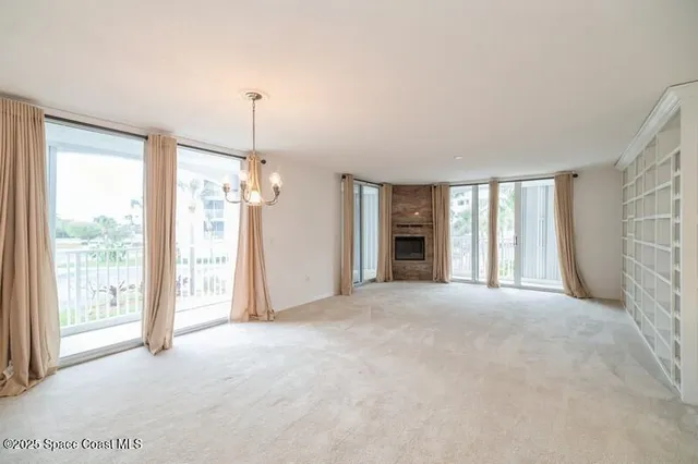 a view of a room with large windows and furniture