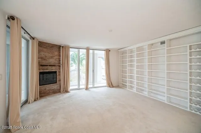 a view of an empty room with a fireplace and a window