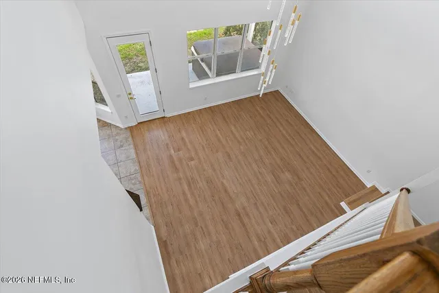 a view of a hallway with wooden floor and entryway