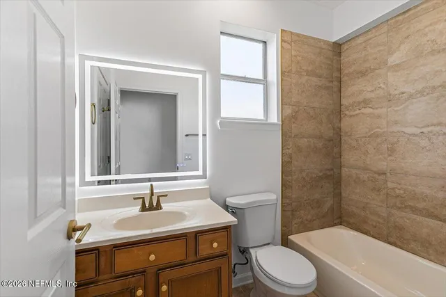 a bathroom with a sink toilet vanity and shower