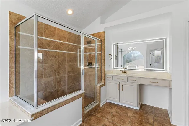 a bathroom with a shower sink and mirror