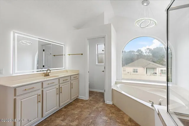 a bathroom with a tub sink and mirror