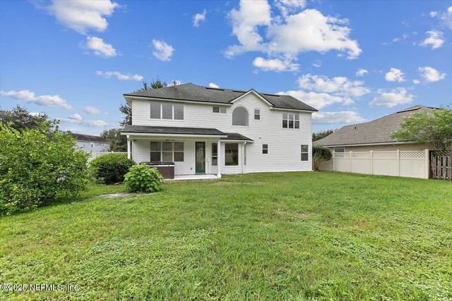 a view of a yard in front of a house with a large tree