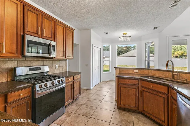 a kitchen with stainless steel appliances a stove sink and cabinets
