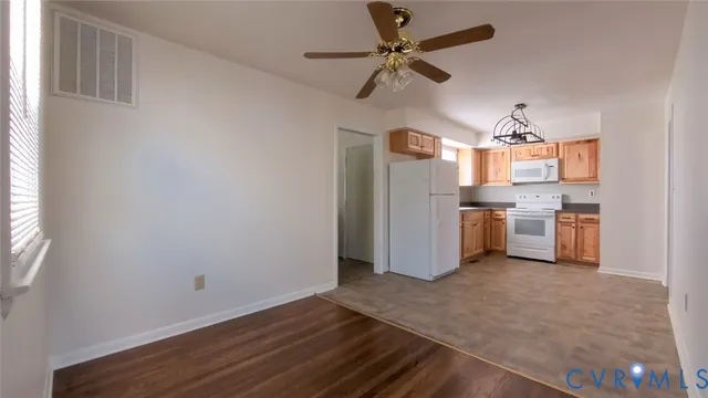 a kitchen with stainless steel appliances a stove top oven a refrigerator cabinets and wooden floor