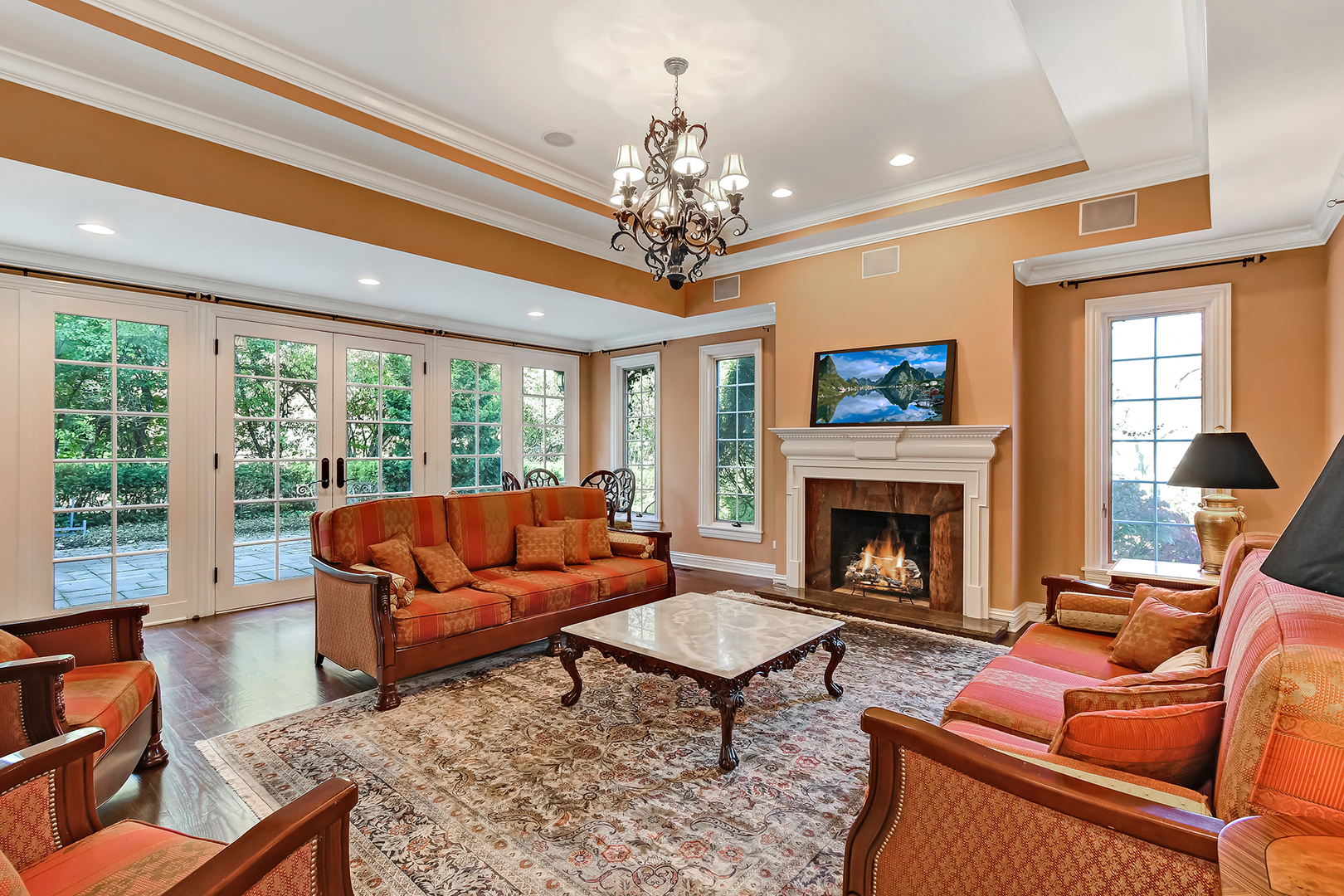6116 South County Line Road Burr Ridge, IL 60527 - Photo 20 of 66 a living room with furniture a chandelier and a fireplace