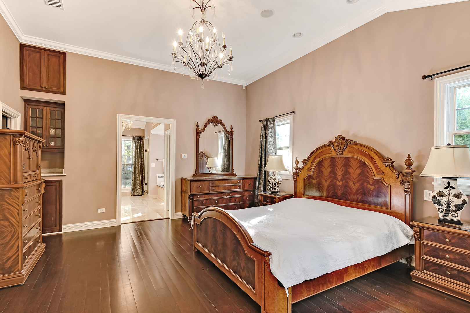 6116 South County Line Road Burr Ridge, IL 60527 - Photo 27 of 66 a bedroom with a bed a chandelier and dresser