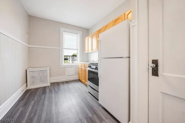 a view of a kitchen with a refrigerator a stove top oven and cabinets