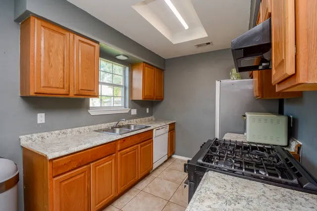 a kitchen with stainless steel appliances granite countertop wooden cabinets and a stove top oven