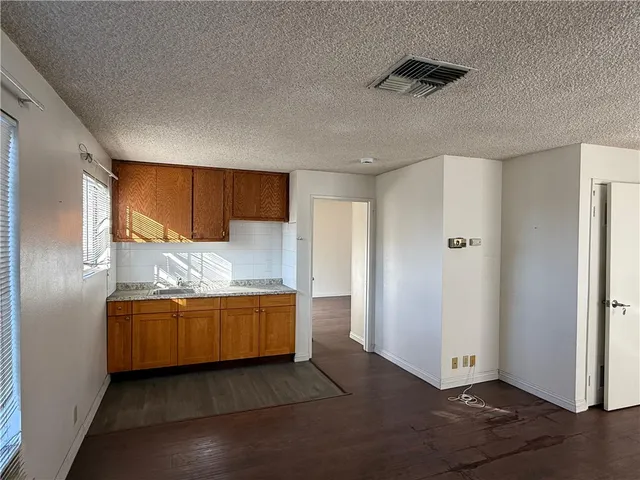 a view of kitchen with stainless steel appliances granite countertop cabinets and wooden floor
