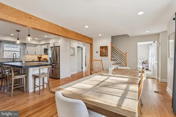 a kitchen with stainless steel appliances kitchen island granite countertop a table chairs sink and cabinets