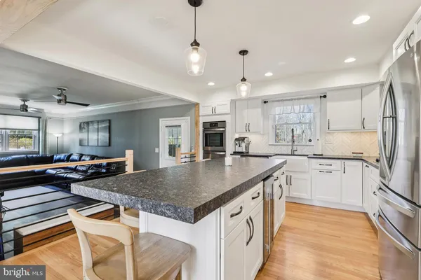 a kitchen with sink a refrigerator and chairs
