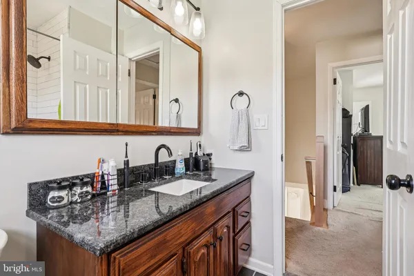 a bedroom with a bed and a lamp on dresser