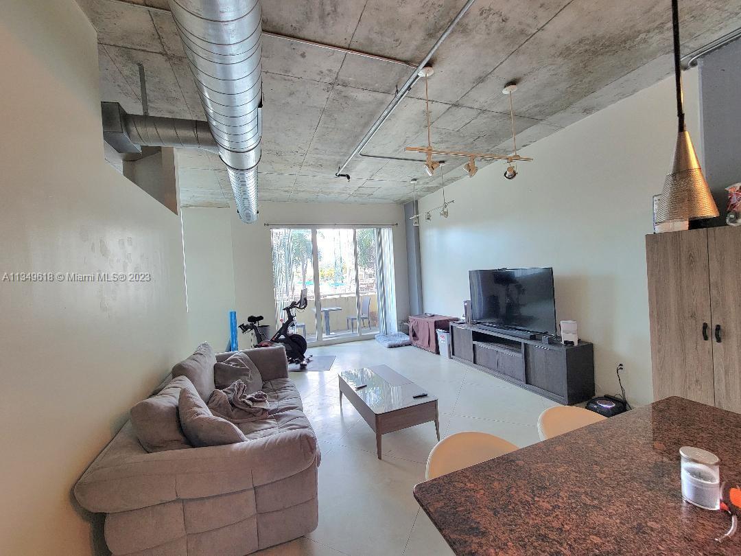 2001 Biscayne Boulevard, Unit 3206 Miami, FL 33137 - Photo 2 of 16 a living room with furniture and a flat screen tv