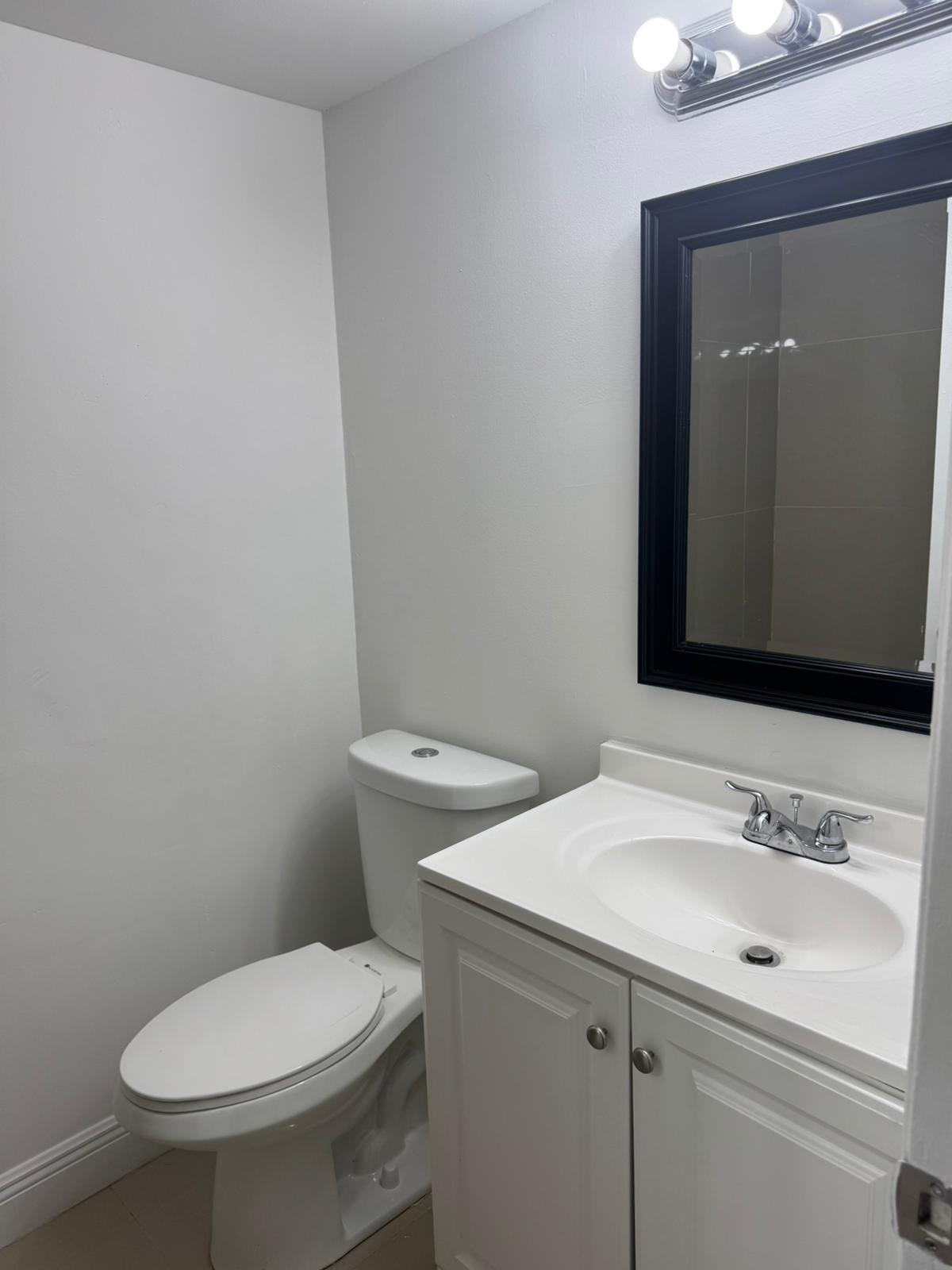 4702 Waterview Circle Palm Springs, FL 33461 - Photo 13 of 22 a bathroom with a sink toilet and mirror