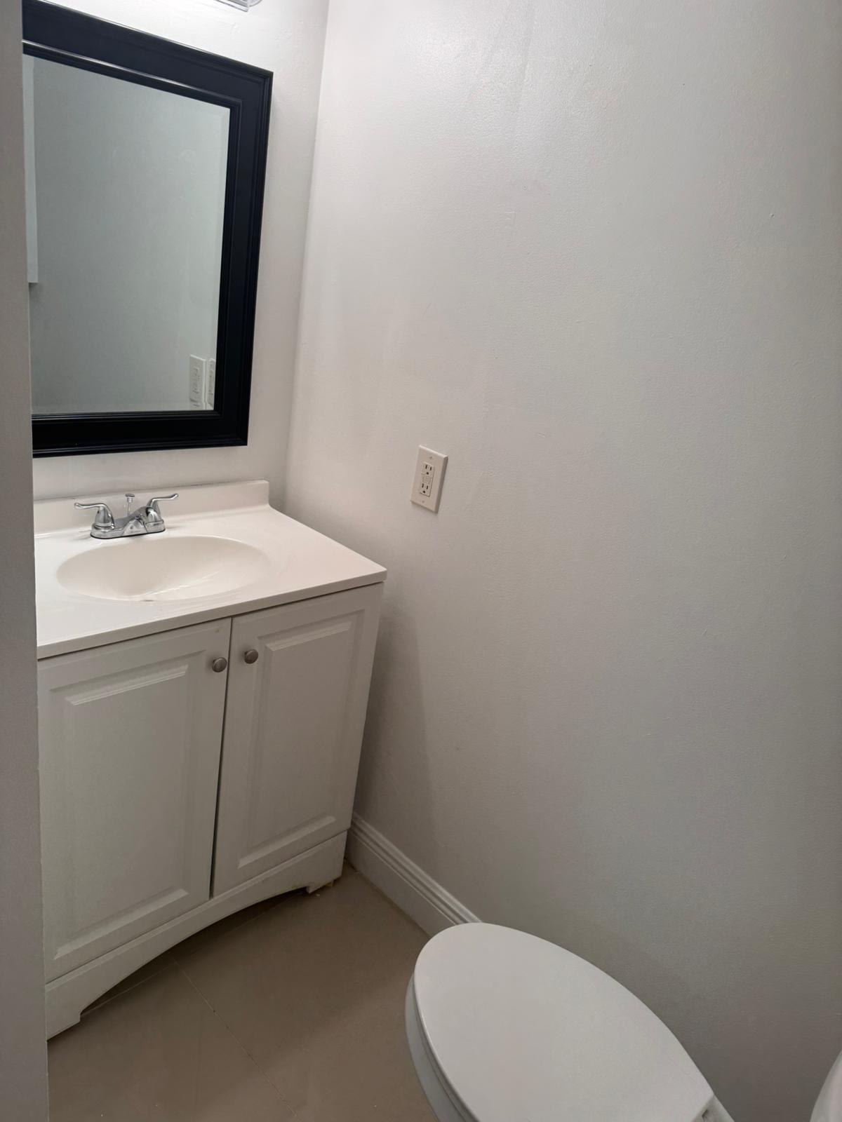 4702 Waterview Circle Palm Springs, FL 33461 - Photo 15 of 22 a bathroom with a toilet sink and mirror
