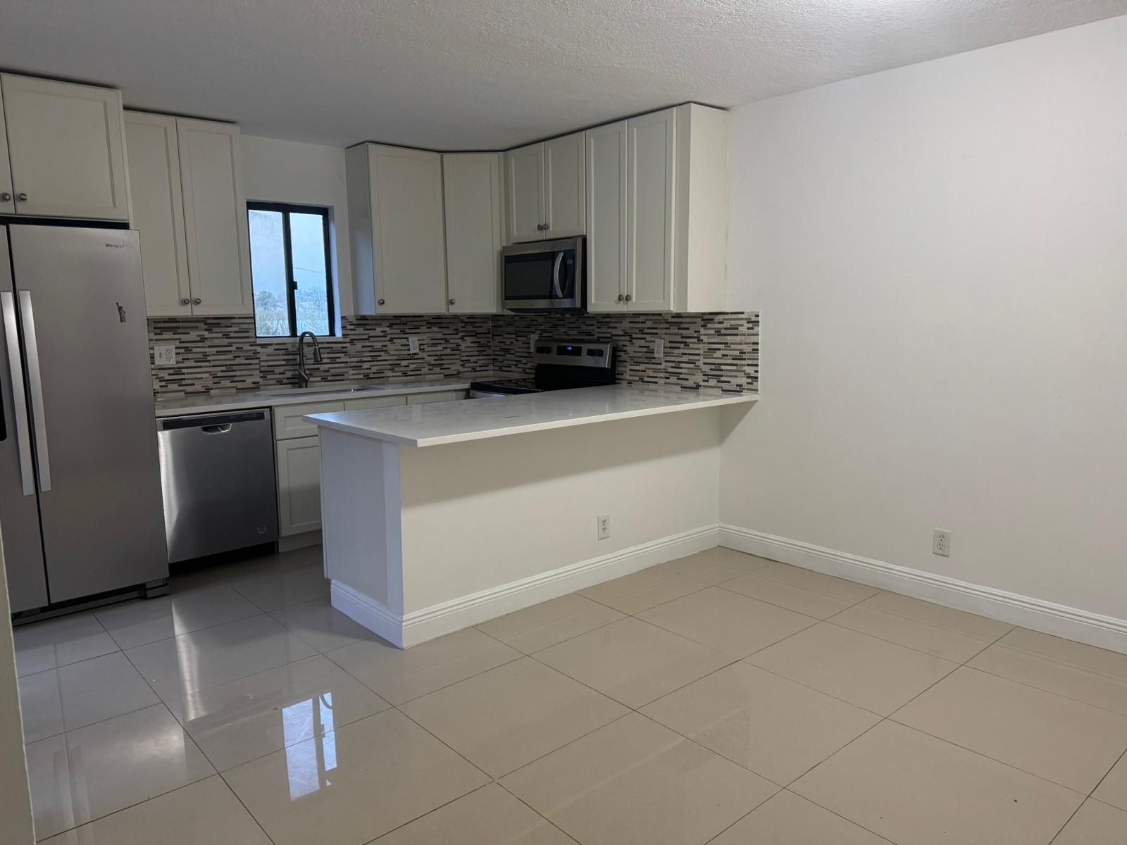 4702 Waterview Circle Palm Springs, FL 33461 - Photo 17 of 22 a kitchen with a sink stove and refrigerator