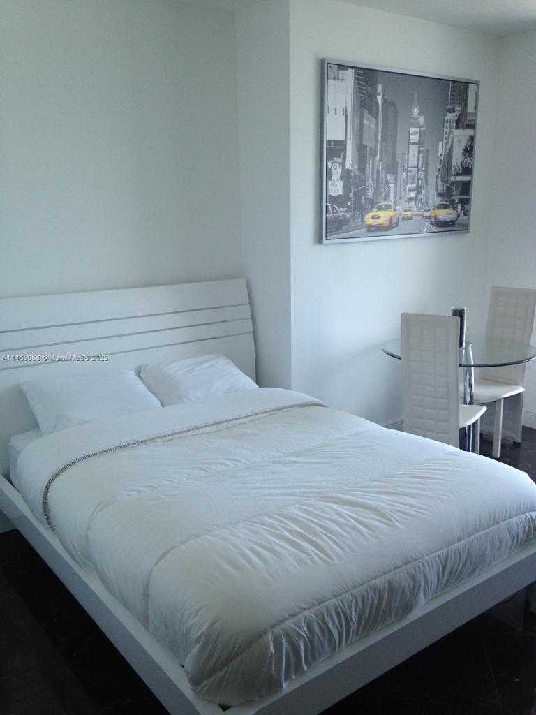 185 Southwest 7th Street, Unit 2206 Miami, FL 33130 - Photo 8 of 12 a bedroom with a bed and night stand