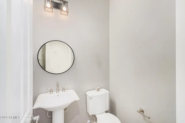 a bathroom with a toilet a sink and mirror