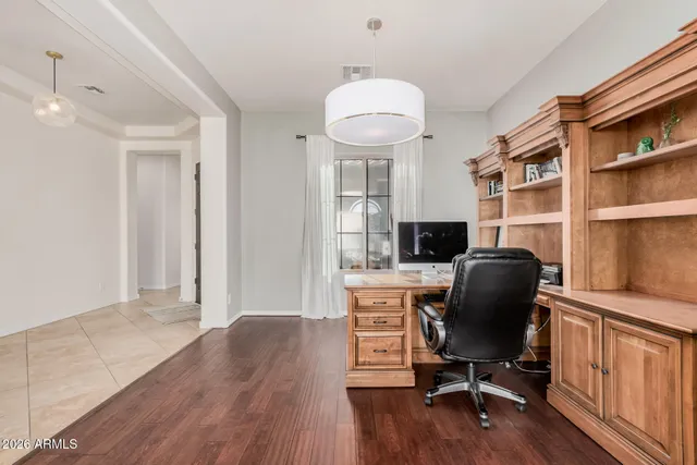 a view of a workspace with furniture and a window