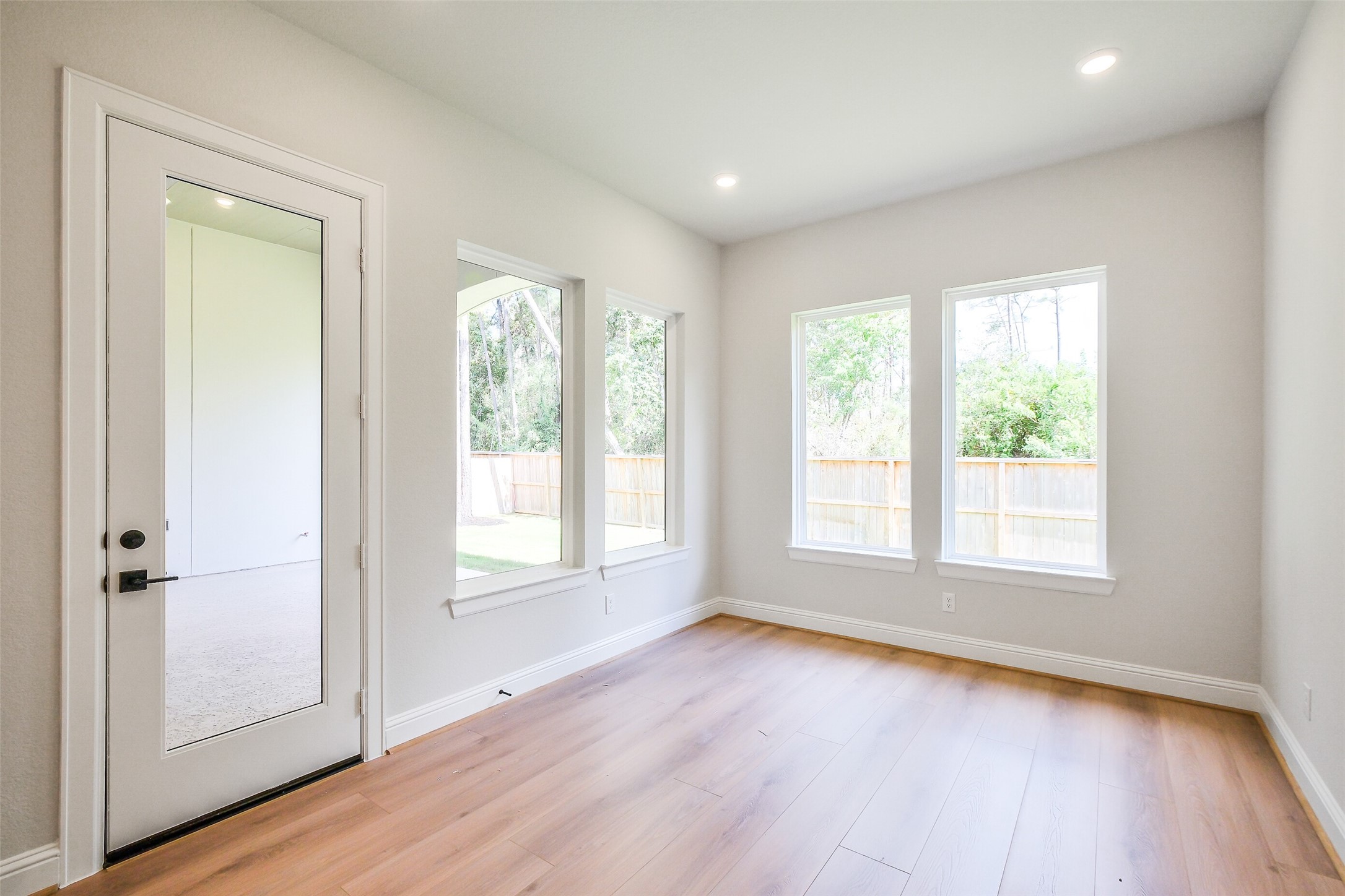 12965 Whitewater Way Conroe, TX 77302 - Photo 21 of 50 an empty room with wooden floor and windows