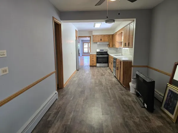 a large kitchen with a wooden floor and stainless steel appliances