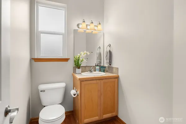 a bathroom with a granite countertop toilet a sink and a mirror