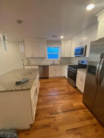 a large kitchen with stainless steel appliances granite countertop a stove a sink dishwasher and a refrigerator