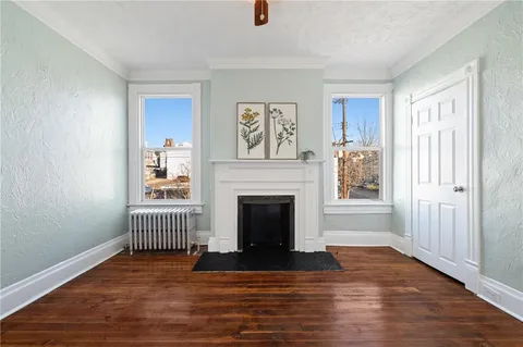 a view of a livingroom with wooden floor and a fireplace