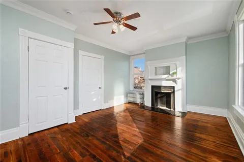 a view of empty room with fireplace and wooden floor
