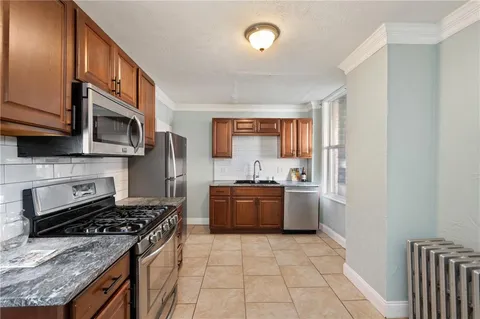 a kitchen with stainless steel appliances granite countertop a stove a sink and a microwave
