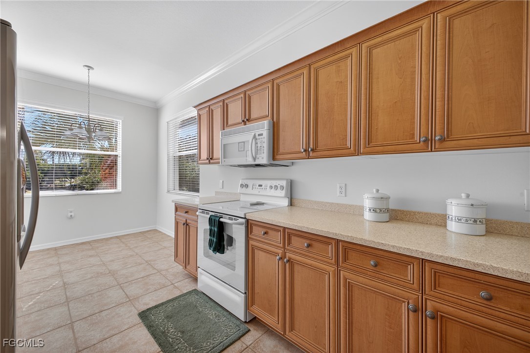 8251 Pathfinder Loop, Unit 621 Fort Myers, FL 33919 - Photo 12 of 32 a kitchen with stainless steel appliances granite countertop a sink stove and cabinets