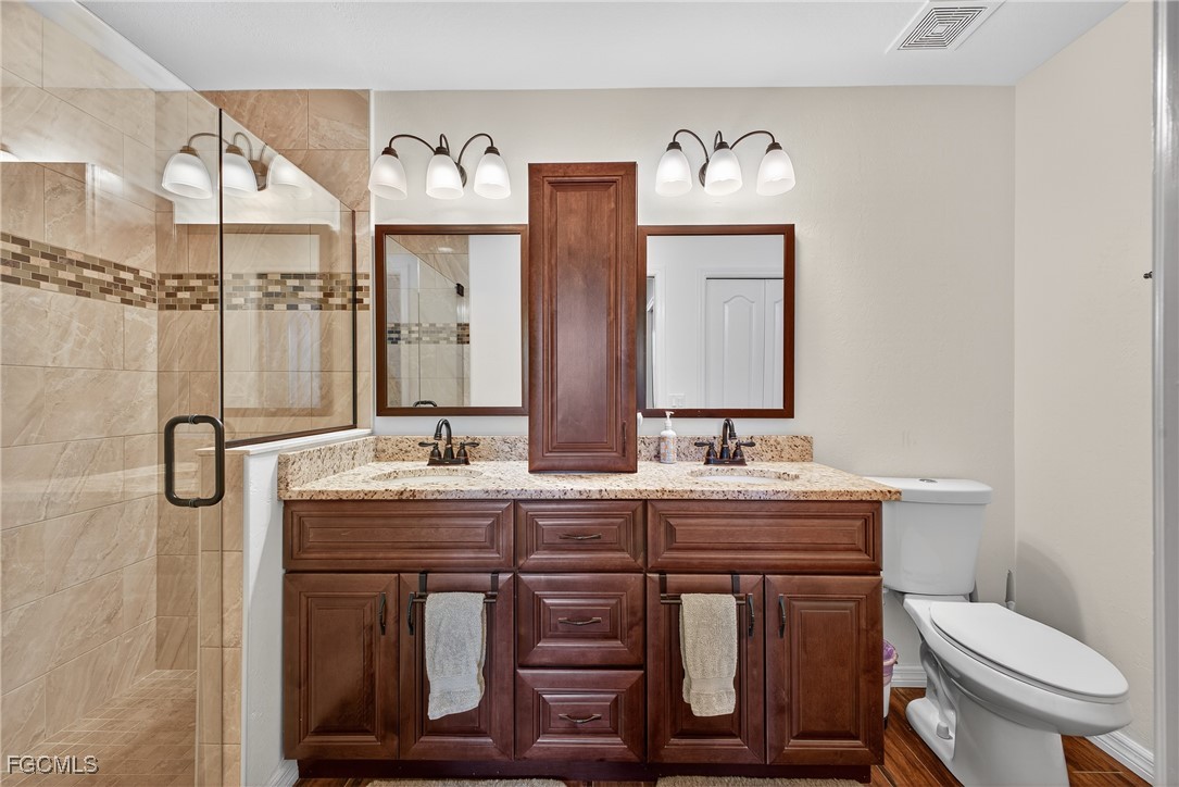 8251 Pathfinder Loop, Unit 621 Fort Myers, FL 33919 - Photo 15 of 32 a bathroom with a granite countertop toilet sink and mirror