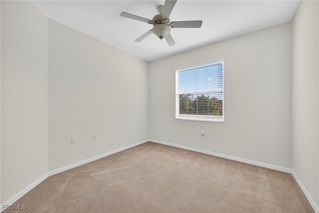 8251 Pathfinder Loop, Unit 621 Fort Myers, FL 33919 - Photo 21 of 32 an empty room with a window and a ceiling fan