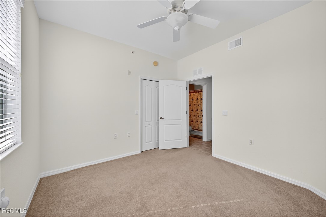 8251 Pathfinder Loop, Unit 621 Fort Myers, FL 33919 - Photo 22 of 32 an empty room with a ceiling fan and a window