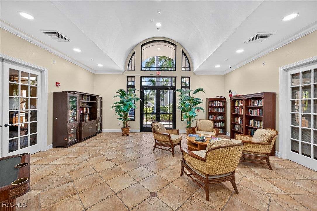 8251 Pathfinder Loop, Unit 621 Fort Myers, FL 33919 - Photo 27 of 32 a living room with furniture a bookshelf and a large window