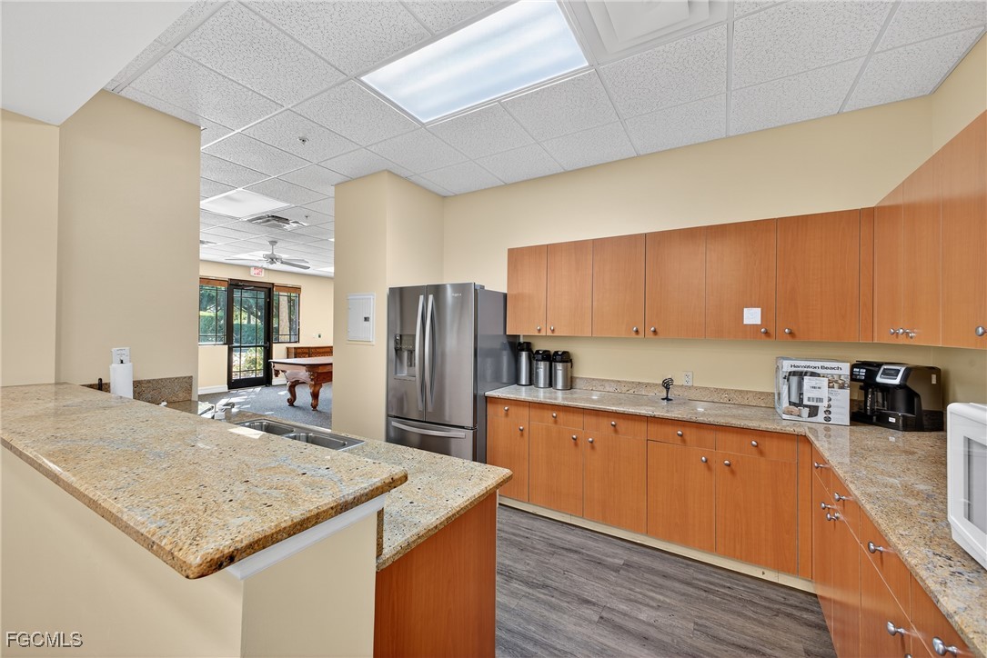 8251 Pathfinder Loop, Unit 621 Fort Myers, FL 33919 - Photo 28 of 32 a kitchen with stainless steel appliances granite countertop a sink refrigerator and cabinets