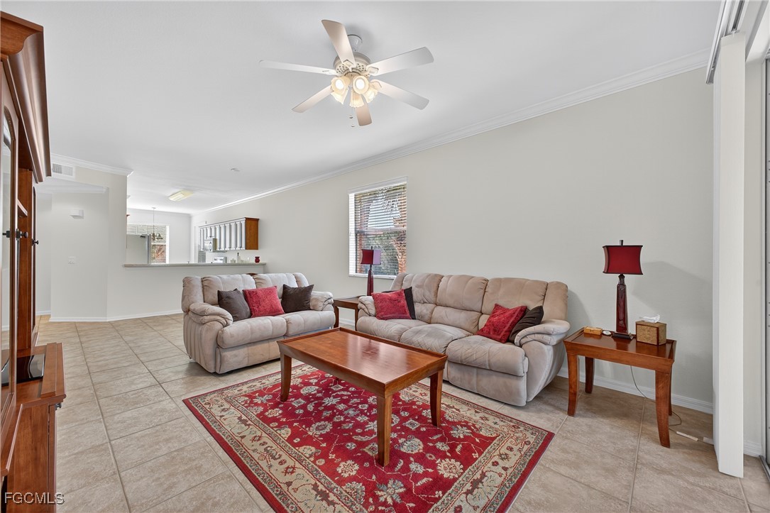 8251 Pathfinder Loop, Unit 621 Fort Myers, FL 33919 - Photo 5 of 32 a living room with furniture a rug and a chandelier