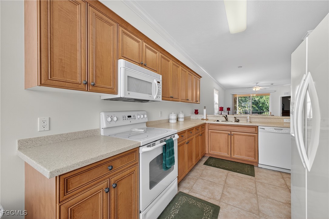 8251 Pathfinder Loop, Unit 621 Fort Myers, FL 33919 - Photo 9 of 32 a kitchen with stainless steel appliances granite countertop a sink and dishwasher a stove top oven with white cabinets