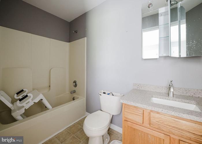 207 Broad Street Hurlock, MD 21643 - Photo 10 of 19 a bathroom with a granite countertop sink mirror vanity and toilet