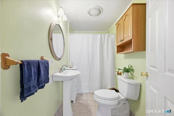 a bathroom with a sink mirror and toilet