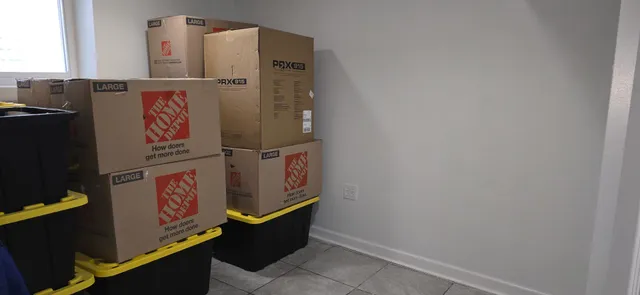 a view of a patio with table and chairs potted plants and floor to ceiling window