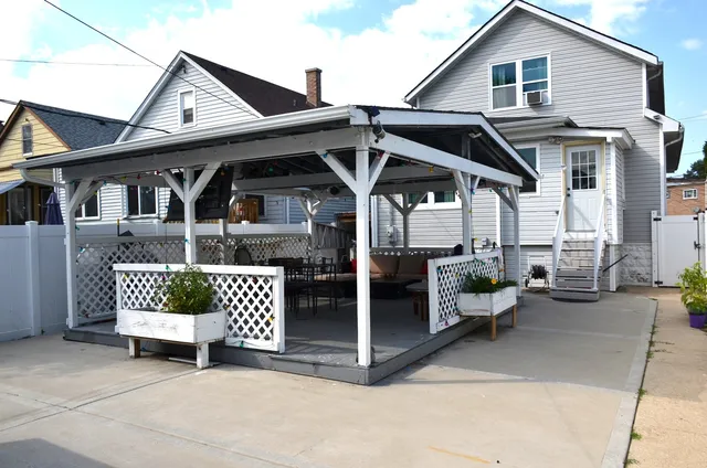 a roof deck with table and chairs a barbeque with wooden fence